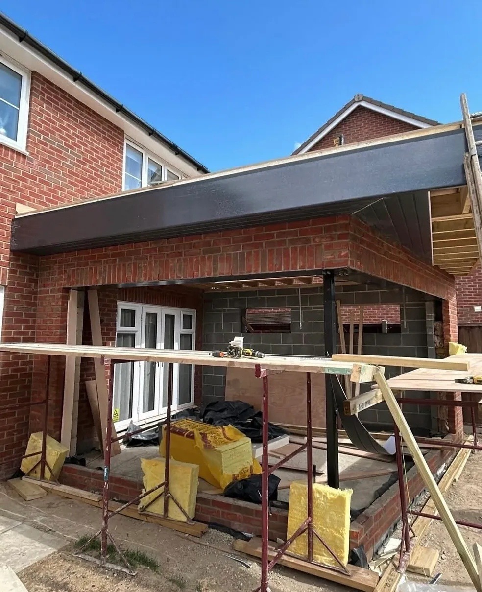 Brick extension under construction with structural steel beams in Cambridgeshire